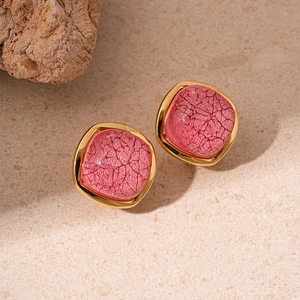 Macro shot of square pink textured resin earrings with elegant golden metal borders