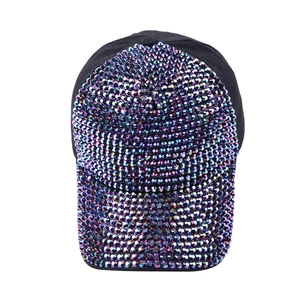Close-up of sparkling purple rhinestones on a black cotton baseball cap surface