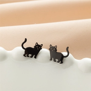 Vue macro de boucles d'oreilles chat noir mat minimalistes sur une assiette décorative
