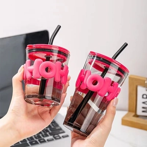 Minimalist glass straw cup with pink silicone sleeve and black straw for coffee lovers