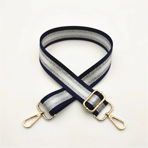 Close-up of adjustable striped handbag strap with silver glitter and gold metal lobster clasps