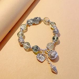 Detail of silver Pixiu bracelet with lotus leaf pendants and pale green beads