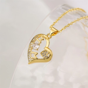 Detailed close-up of golden heart pendant with MOM lettering and zircon inlay