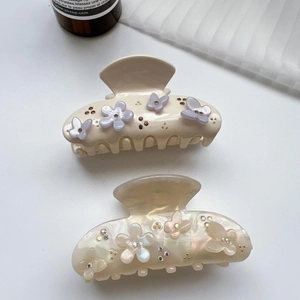 Détails des pinces à cheveux en acétate beige avec motifs papillon fleur et cristaux