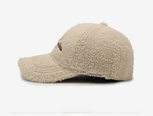 Vue détaillée de la casquette beige en polaire teddy avec broderie de texte élégante