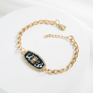 Detail of gold Scorpio constellation bracelet with black enamel and sparkling rhinestones