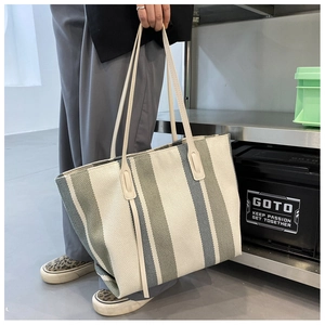 Detail showing high-capacity canvas tote bag with wide beige and grey-green vertical stripes
