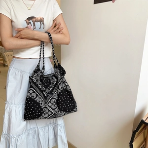 Detail of floral tote bag with black and white paisley print and fabric texture