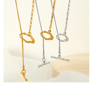 Detailed close-up of minimalist gold and silver snake chains with irregular OT clasps