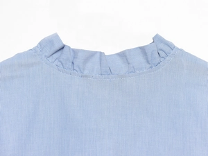 Close-up of ruffled stand collar and blue pinstripe texture on cotton poplin shirt