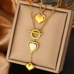 Detailed close-up of double-layer gold heart necklace with OT buckle and white shell inlay