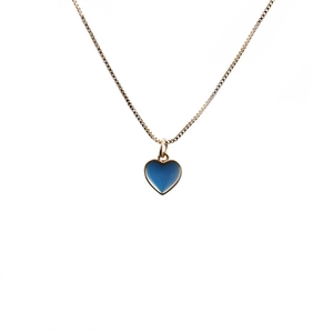 Close-up of a blue enamel heart pendant on a delicate gold box chain necklace