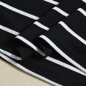 Close-up of black and white striped ribbed knit fabric showing fine texture and stitching
