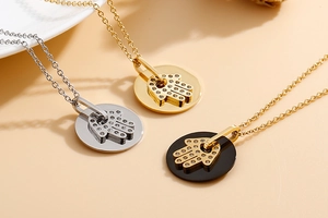 Detailed view of three Hamsa Hand necklaces in gold and silver with sparkling rhinestones