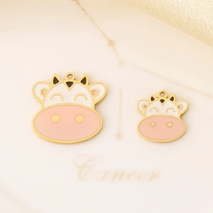 Close-up of gold-plated cow head enamel charms for DIY jewelry making sets