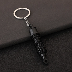 Matte black car shock absorber keychain made of metal with realistic spring detail