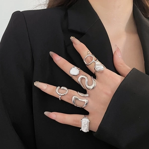 Close-up of silver irregular liquid metal rings and pearl set on model's hand