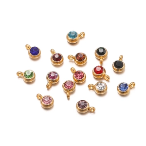 Macro shot of colorful round cubic zirconia charms with gold plated hanging loops