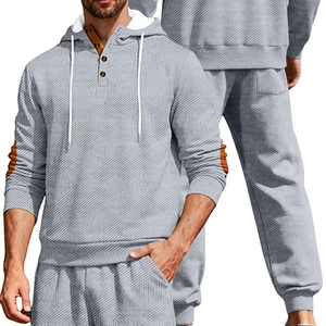 Detail view of men's grey tracksuit featuring textured jacquard fabric and hooded collar