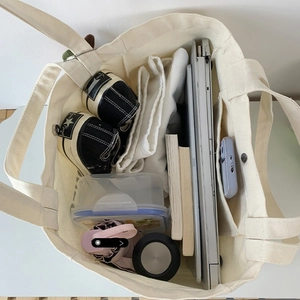 Macro interior view showing large capacity and multi-pocket storage of the canvas tote bag