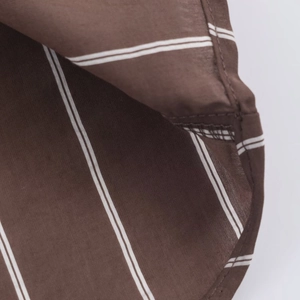 Macro shot of stitching detail and fabric texture on dark brown striped shirt