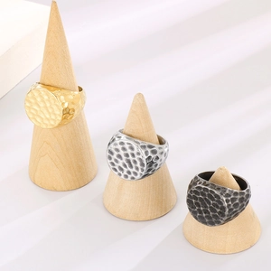 Detailed close-up of hammer-textured metal rings in gold, silver, and antique finishes
