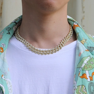 Close-up of gold iced-out Cuban link chain with sparkling stones worn by male model