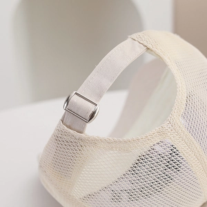 Detail of beige mesh baseball cap featuring an adjustable metal buckle and breathable fabric