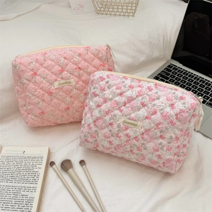 Quilted floral cosmetic bags in a cozy lifestyle setting with soft pink floral patterns