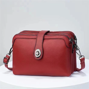 Red pebbled leather crossbody bag with three-tier structure and metal twist lock