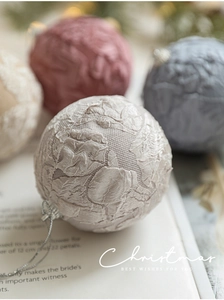 Close-up of jacquard fabric Christmas ball with embossed floral texture and silver cord