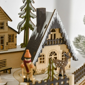 Close-up of wooden Christmas advent calendar with snow-covered cottage and cedar trees