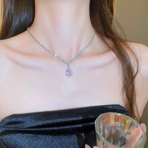 Close-up of pink teardrop crystal necklace on model featuring sparkling diamond accents
