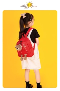 Girl wearing a lightweight red kindergarten backpack with a cute plush bear detail