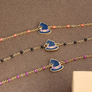 Detail of Halloween gold chains with witch hat pendants and colorful beads on dark background