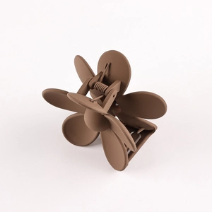 Detail view of a brown matte flower hair claw clip with a durable metal spring mechanism