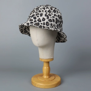 Detail of leopard print bucket hat on a mannequin head showing ruffled brim and canvas texture