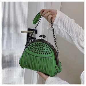 Detail of green punk shell bag featuring metal rivets, fringe chains and clasp closure