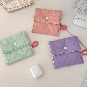 Detailed macro view of quilted heart pattern mini pouches in pink, mint green and purple