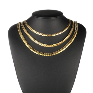 Three-layer golden flat curb chain necklaces displayed on black bust model