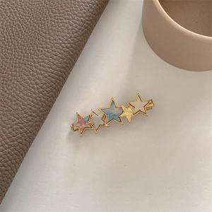 Close-up of heart acetate hair clip with five colorful stars and gold metal base