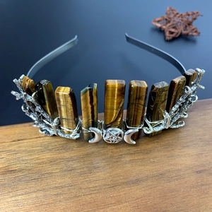 Macro detail of tiger eye crystals and silver triple moon goddess on the bridal headband