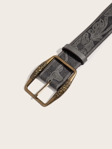 Detail view of American retro Y2K leather belt with vintage floral embossing and brass buckle