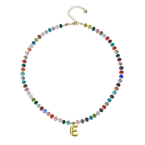 Detailed shot of beaded necklace with gold letter E pendant and heart charm on extension chain