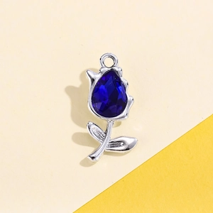 Detailed close-up of a silver tulip charm pendant featuring a deep blue teardrop gemstone