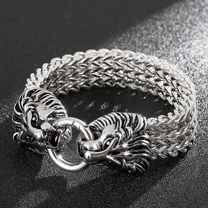 Macro view of double lion heads clasp on a silver braided stainless steel bracelet