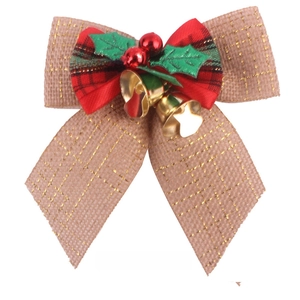 Detail of Christmas burlap bow with plaid ribbons, holly leaves and golden bells