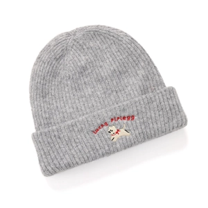 Close-up of grey knit beanie featuring lucky plegg embroidery and white cartoon dog pattern