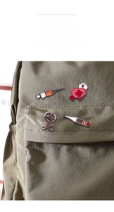 Broches médicales en émail avec stéthoscope et seringue sur un sac à dos en toile