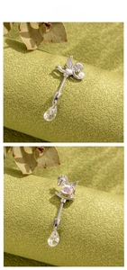 Macro detail of silver rocking horse and angel cartilage studs with teardrop crystals